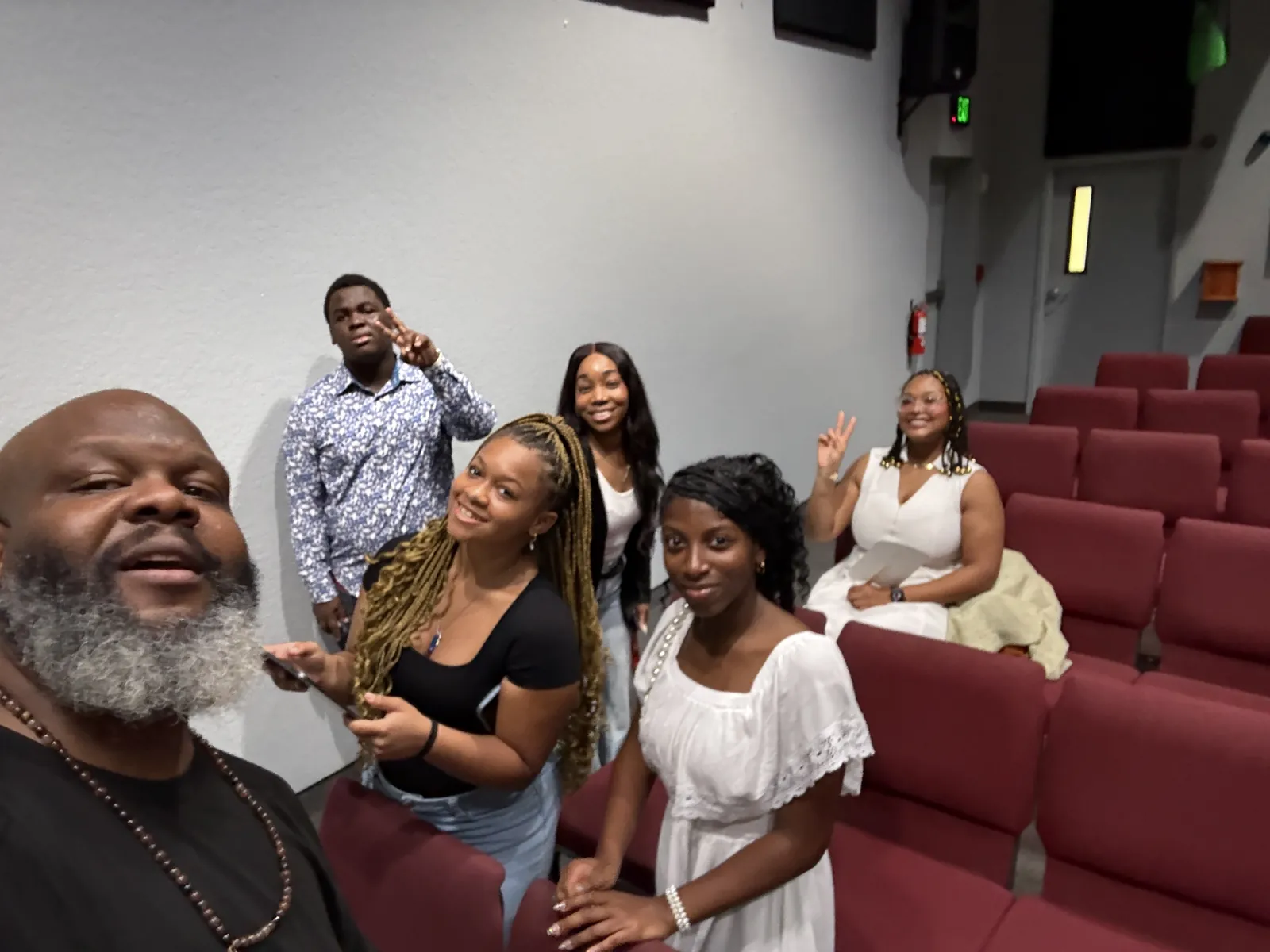Younger Choir members smiling together between the sanctuary seats