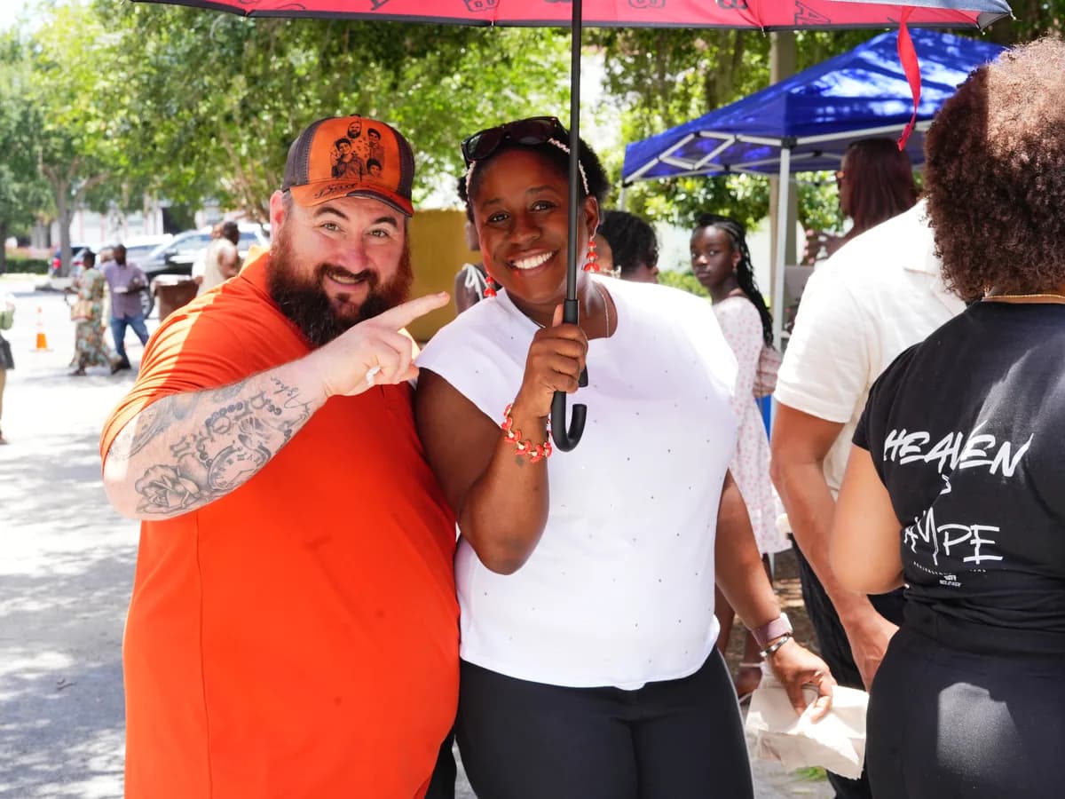 Two volunteers in outreach shirts laughing together at a church event